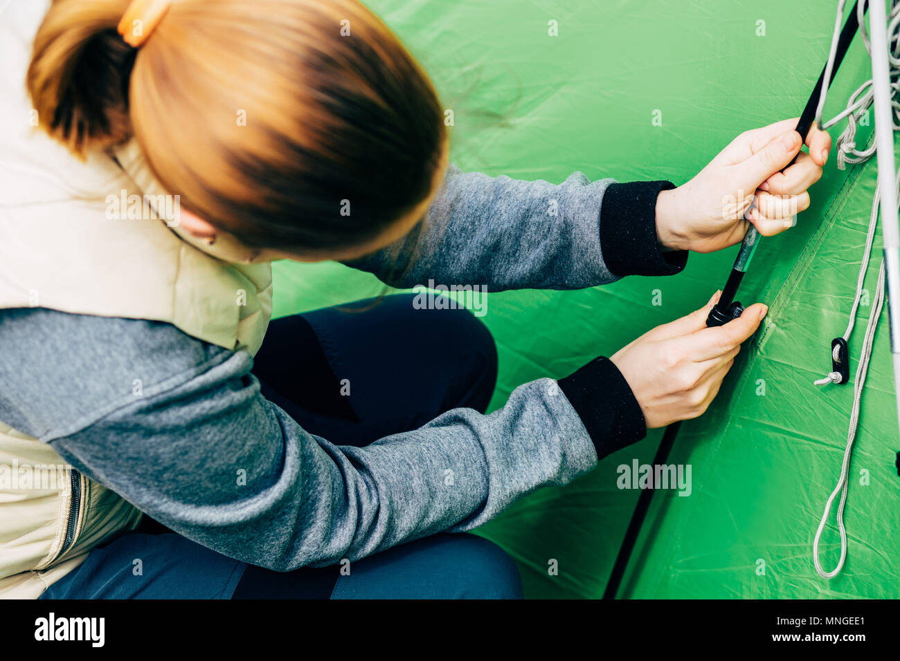 female hiker putting up tent Stock Photo