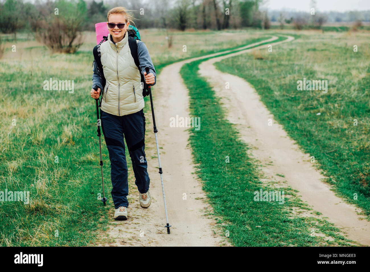 Caucasian woman hiking on rural trail Stock Photo