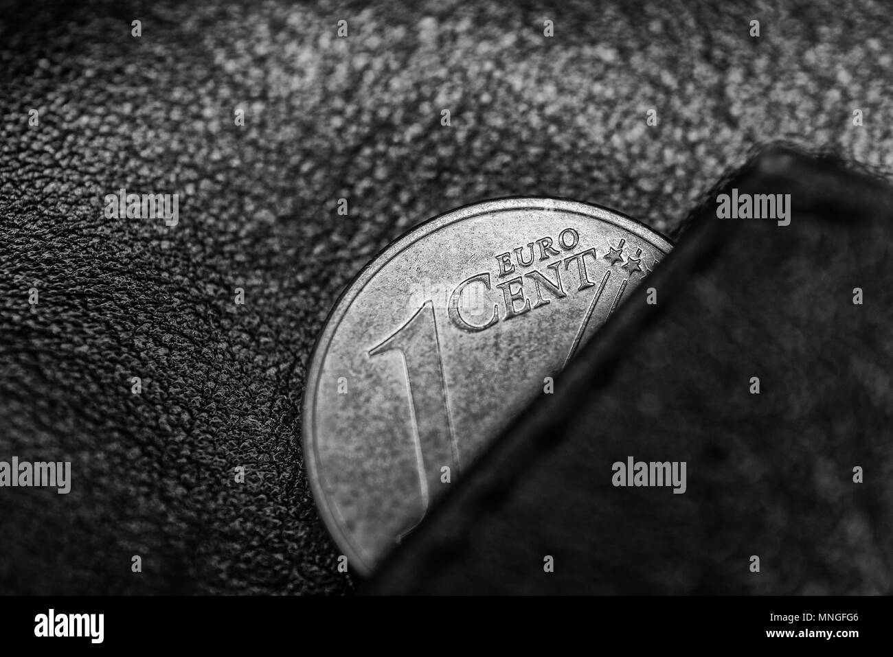 Black and hite photo of black leather wallet and one cent of euro, to symbolize poverty, bankrupt or thrift, frugality and economy Stock Photo