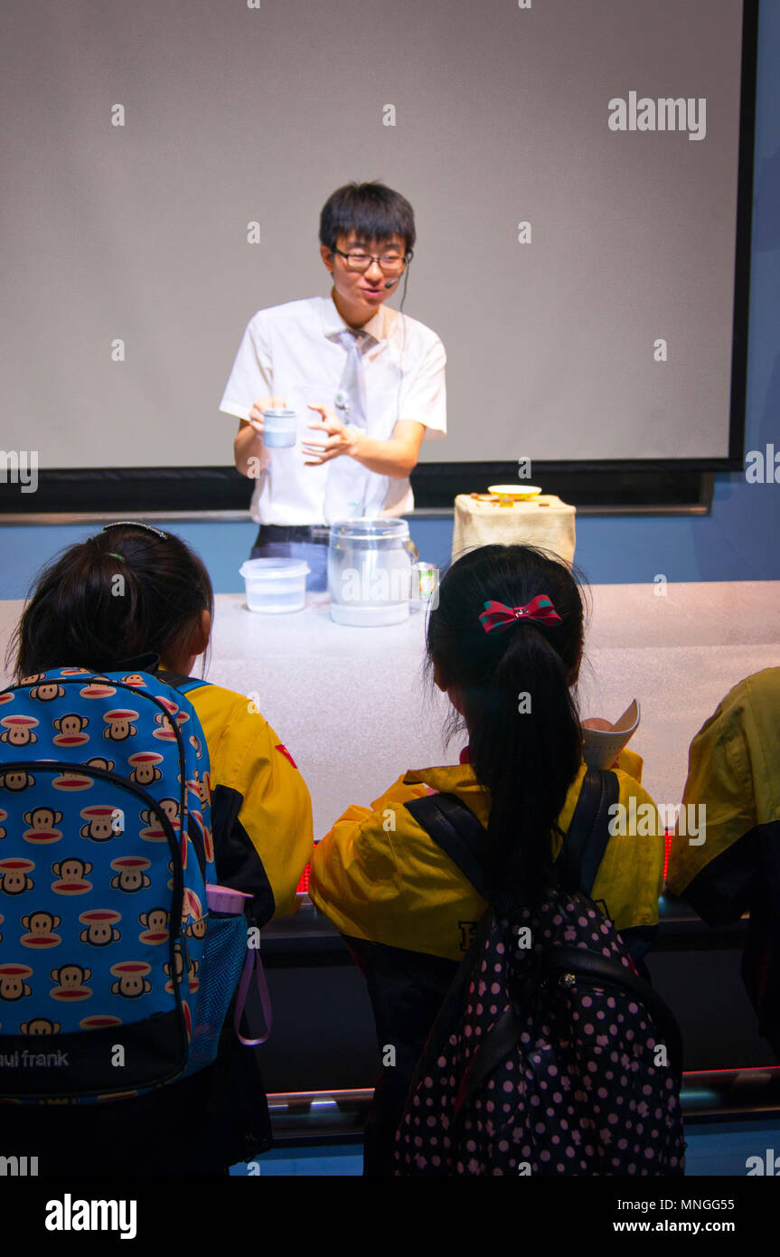 Museum science presenter talking to Chinese school children at the China Science and Technology Museum in Beijing, China. Stock Photo