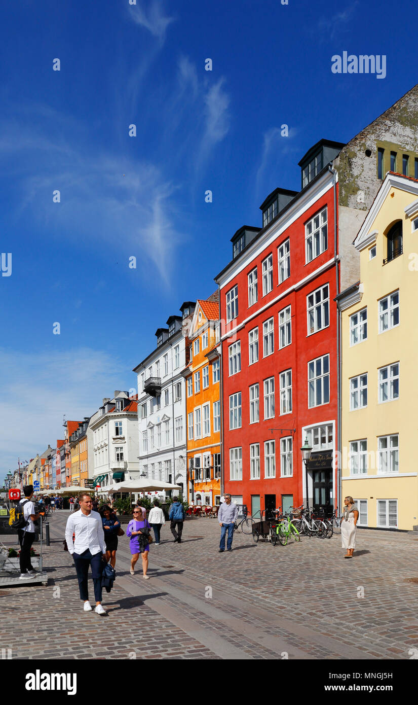 Copenhagen, Denmark - August 24, 2017: Street view of the colorful building in Nyhavn in Cophenhagen with people walking the street in front. Stock Photo