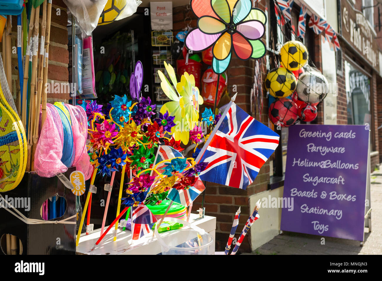 A British Union Jack flag sits among other outdoor toys and games items outside a high street gift and craft shop. Stock Photo