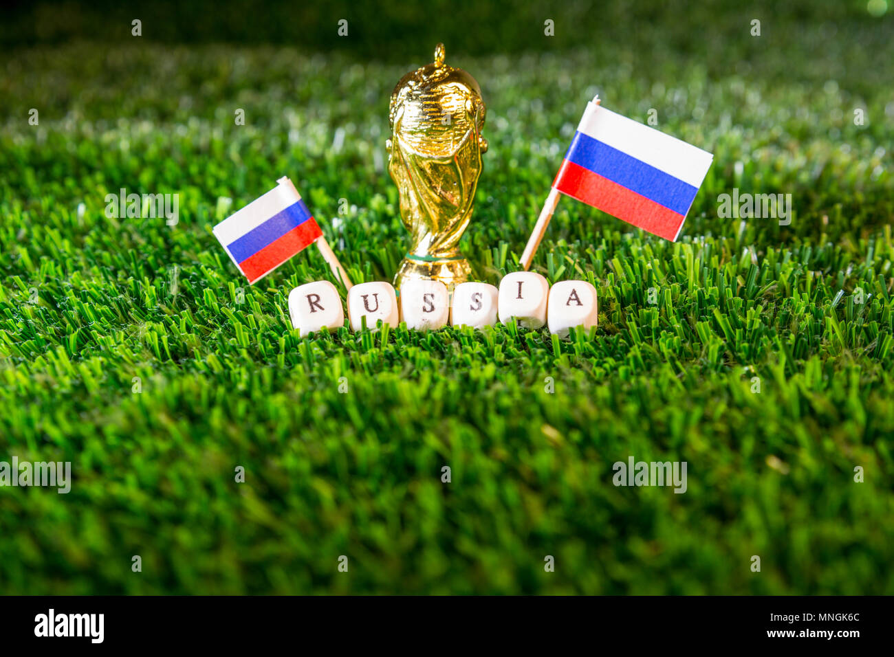 Barcelona, Spain, May 2018: Fifa World Cup concept illustrative editorial. Golden trophy, russian flags and over green grass. Stock Photo