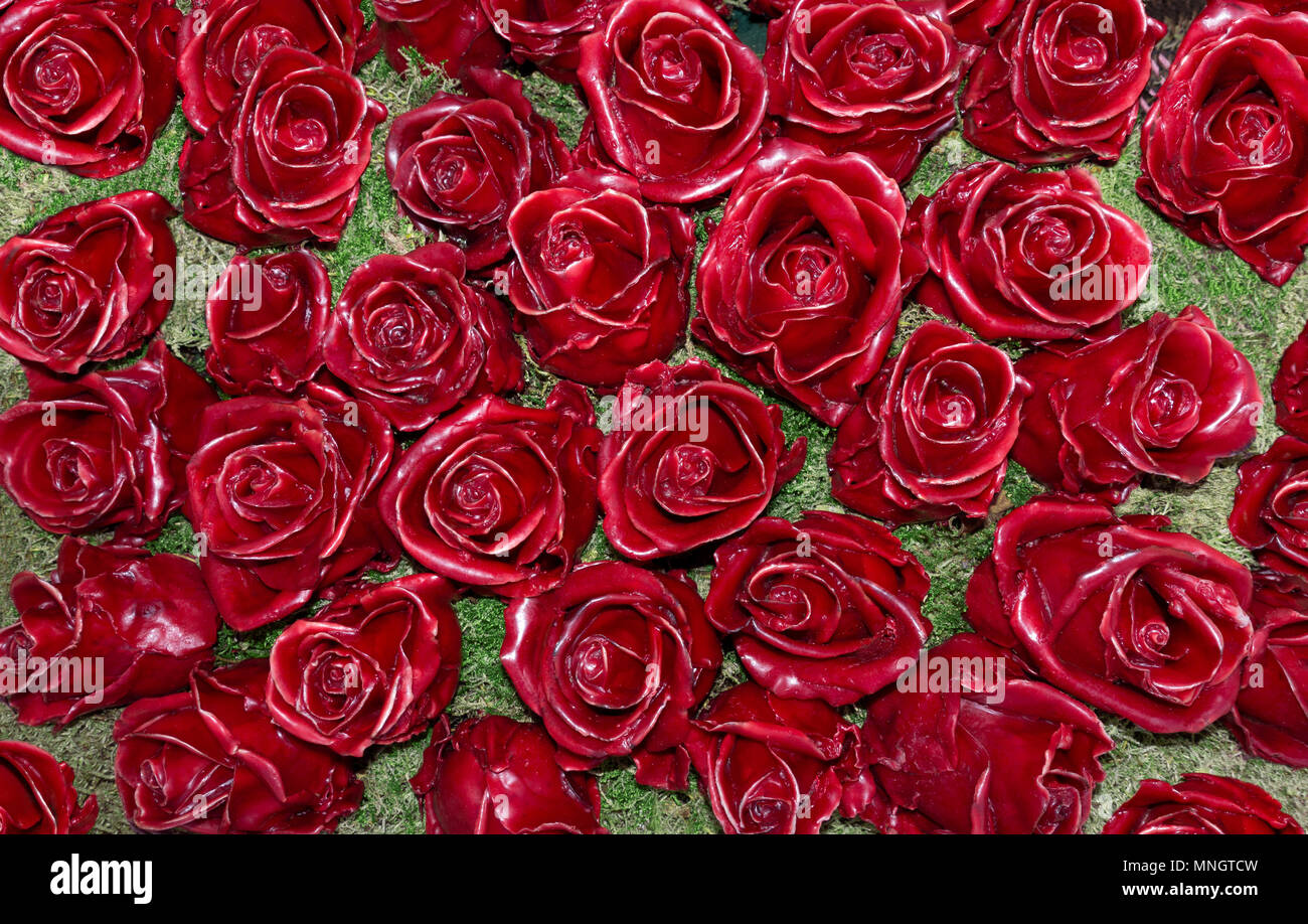 Red roses made of wax on moss Stock Photo