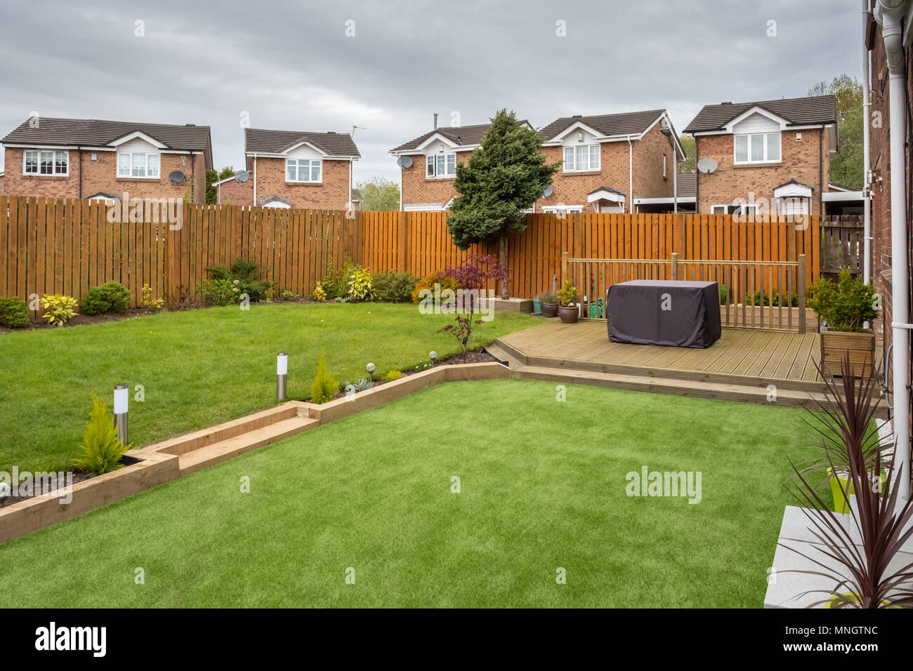 A modern garden with  a new planted lawn decking shrubs  and borders. Designed and owned by contributor. A good image for Landscape gardiners or desig Stock Photo