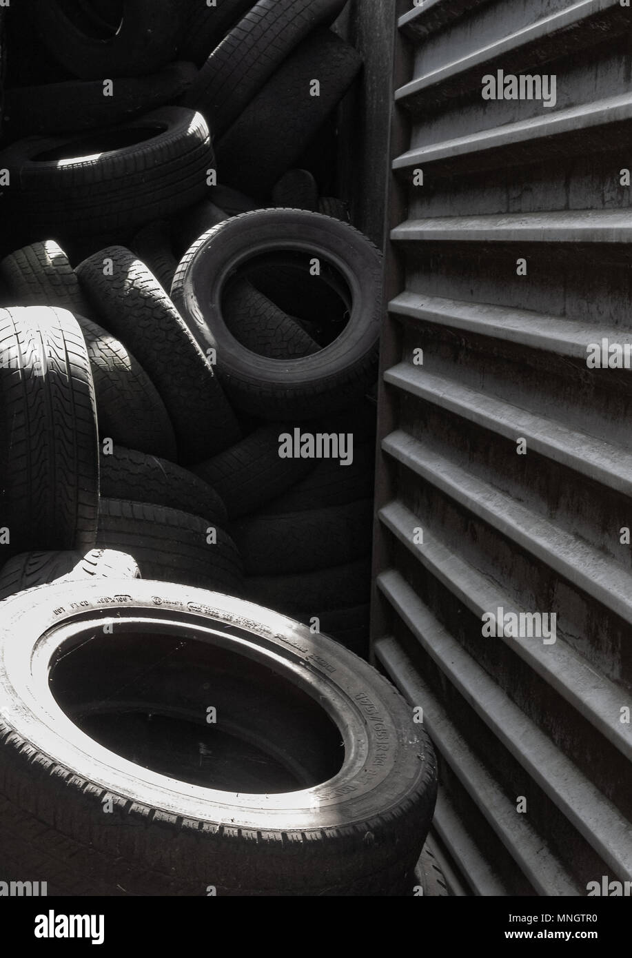 Pile of tyres against a shed Stock Photo