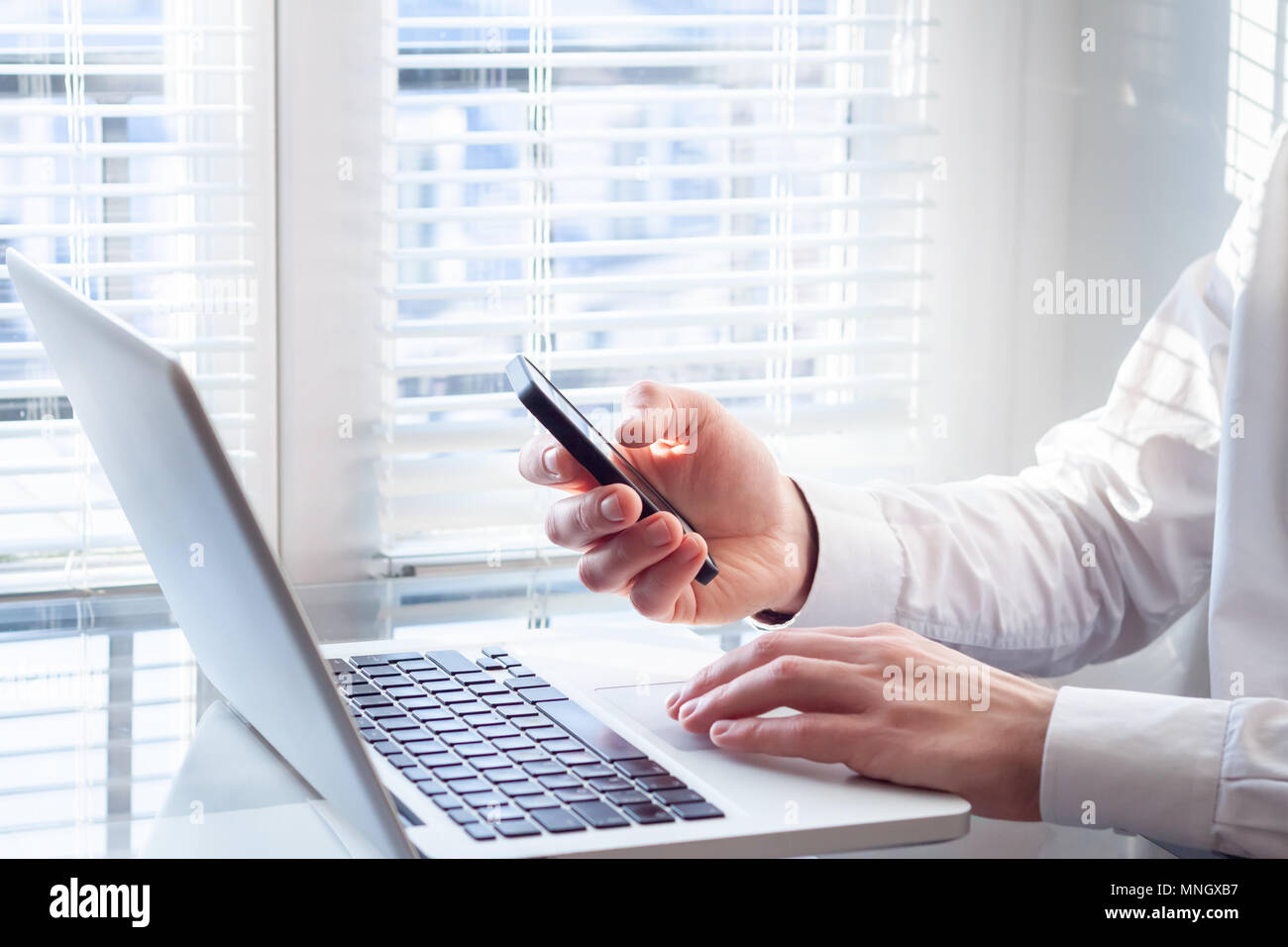 Businessman working with laptop computer and smartphone in bright office, financial accountant, corporate business investment consultant Stock Photo