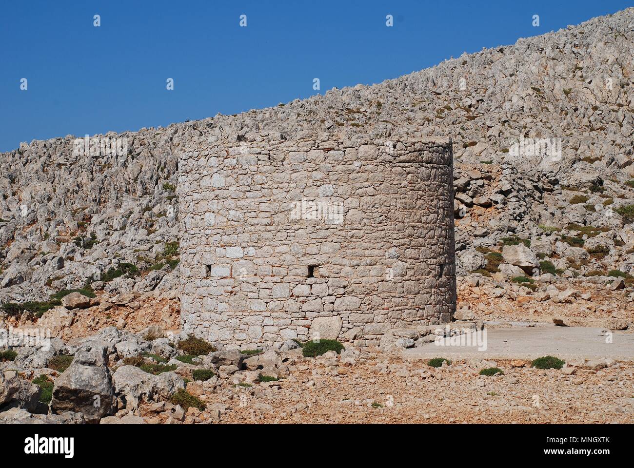 An old stone windmill on the high plateau of the Greek island of Halki on June 12, 2015. Stock Photo