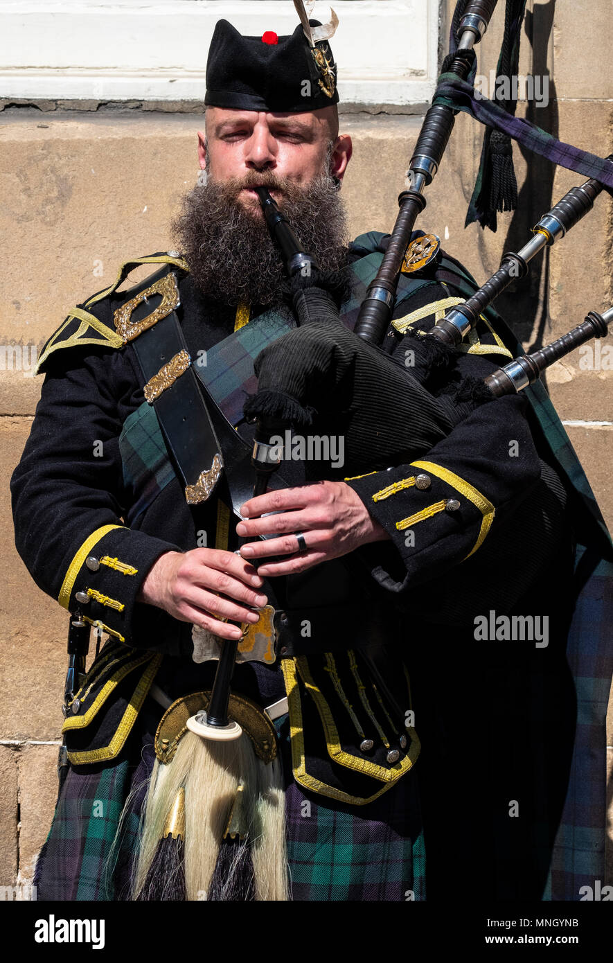 View of traditional Scottish piper in tartan playing for tourists on the Royal Mile in Edinburgh, Scotland, UK Stock Photo