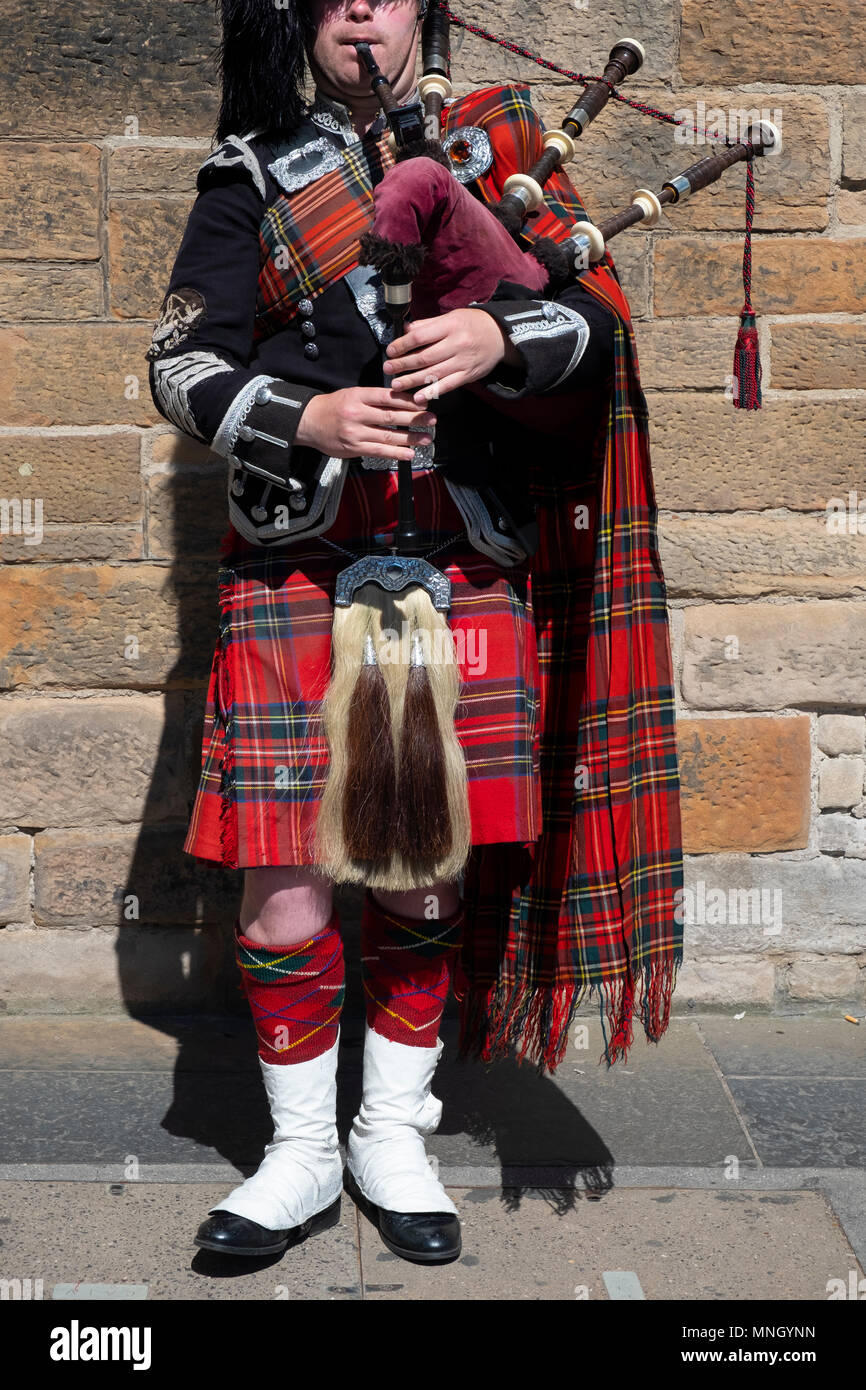 View of traditional Scottish piper in tartan playing for tourists on the Royal Mile in Edinburgh, Scotland, UK Stock Photo