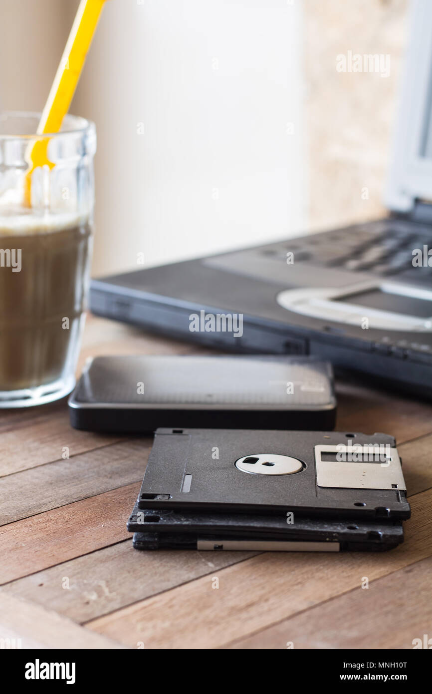 diskette on blur coffee in cup and blur notebook background, Stock Photo