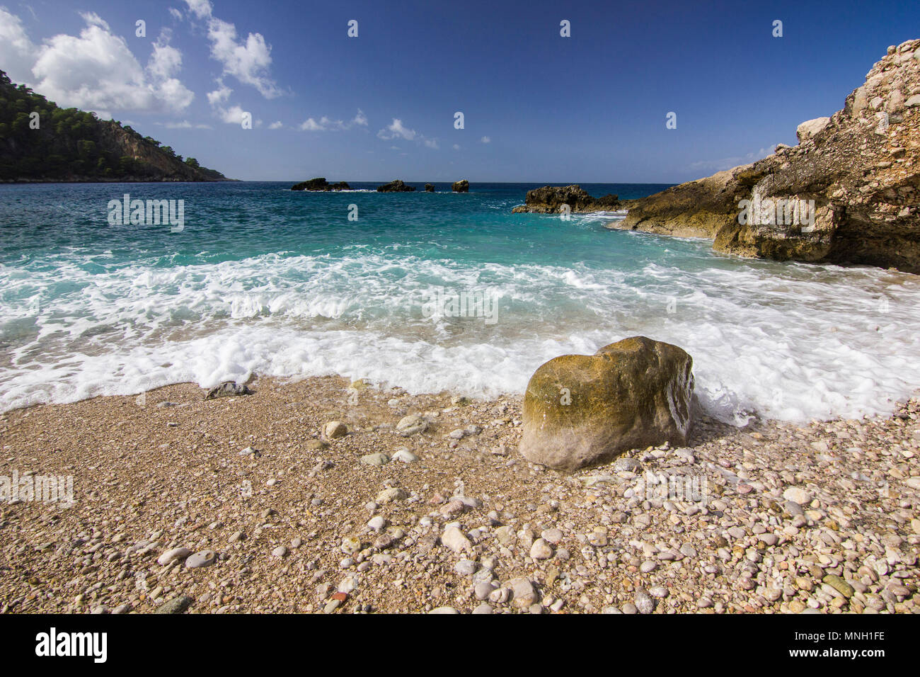 colorful sunrise on mediterranian sea with white waves near the sand shore Stock Photo