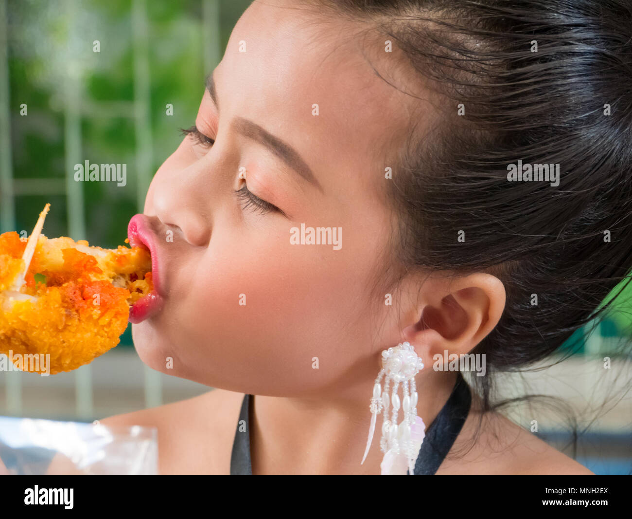 Cute little Girl eating the delicious fried chicken Stock Photo