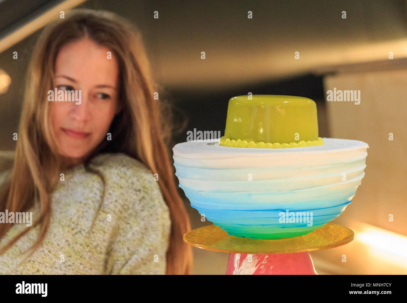 Westminster, London, 17th May 2018.  An assistant looks at “Floating flødeboller”, the cake special Royal Wedding Cake by designer and cake maker Kia Utzon-Frank, who created her own special suspended Royal Wedding Cake, made of 24 chocolate spheres hanging in a ring formation. In advance of Clerkenwell Design Week (22 – 24 May), some of London’s leading creatives, in partnership with top bakers, have been commissioned, to create their own dream wedding cake for Meghan and Harry to celebrate the Royal Wedding on the 19th May. Credit: Imageplotter News and Sports/Alamy Live News Stock Photo