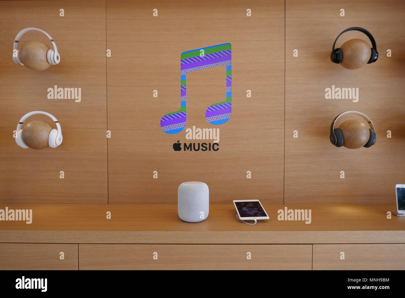 07 May 2018, USA, Cupertino: The logo of music streaming service Apple Music, surrounded by Beats headphones and a Homepod speaker, pictured in the Apple Store at the new company headquarters Apple Park.  - NO WIRE SERVICE - Photo: Christoph Dernbach/dpa Stock Photo
