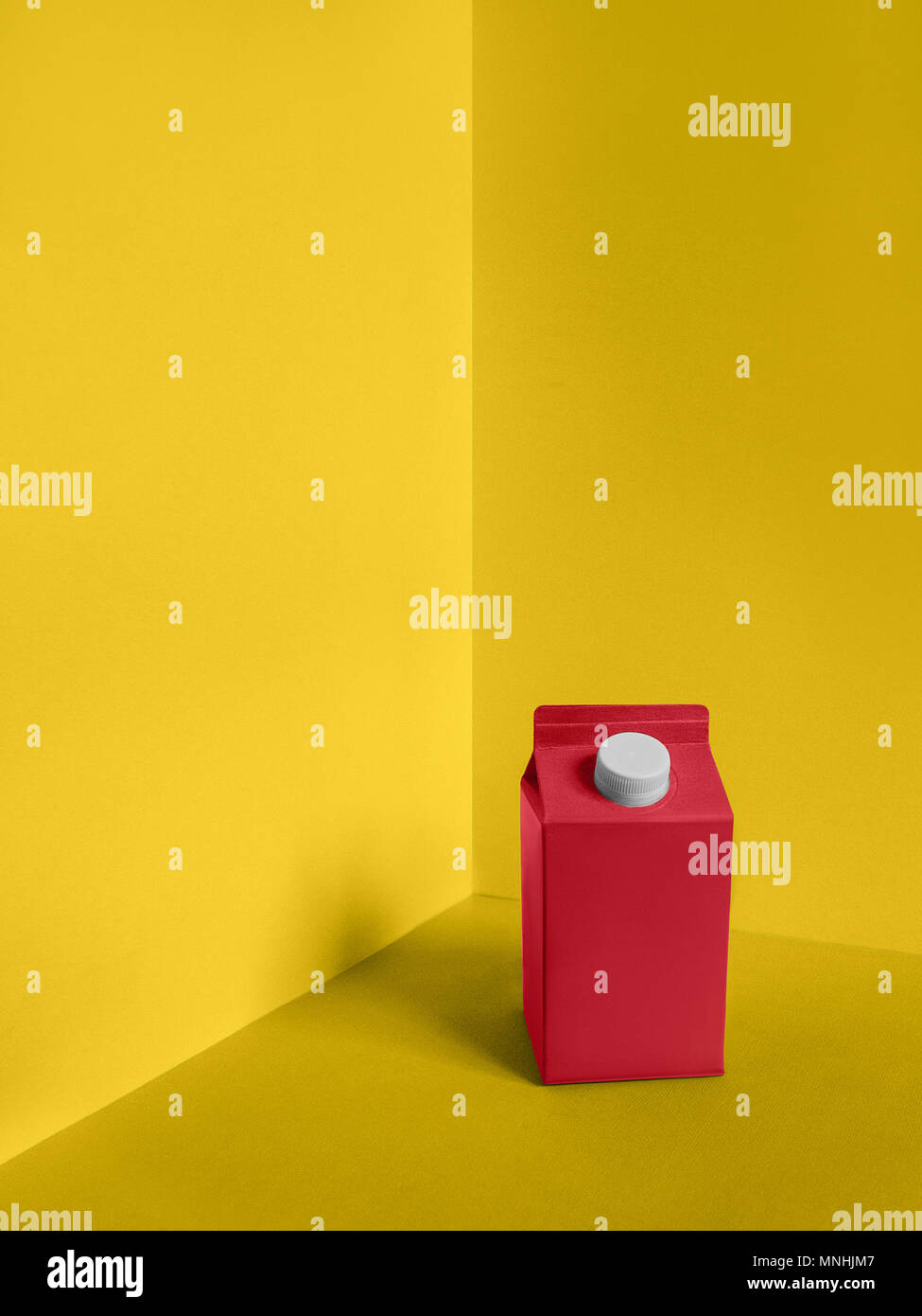 Milk package Pop art Bright pink carton of milk is standing on a yellow ...