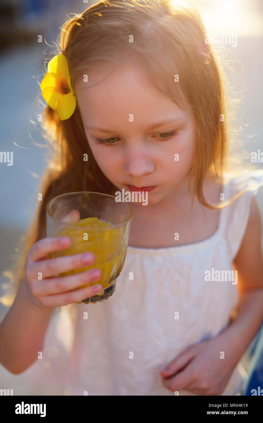 Adorable little girl drinking juice from a glass Stock Photo
