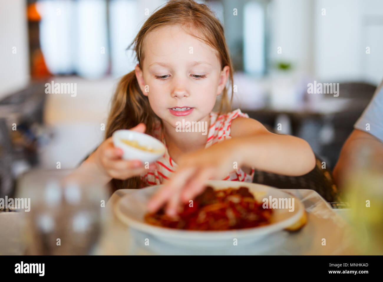 Portrait of adorable little girl eating lunch at restaurant Stock Photo