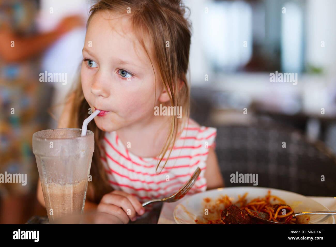 Portrait of adorable little girl having lunch at restaurant Stock Photo