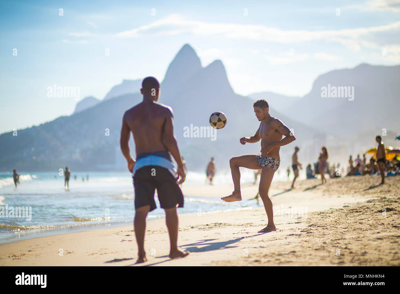 RIO DE JANEIRO, BRAZIL - CIRCA MARCH 2018: Young Brazilians play a game of beach football keepy-uppy 'altinho' on the shore of Ipanema Beach. Stock Photo