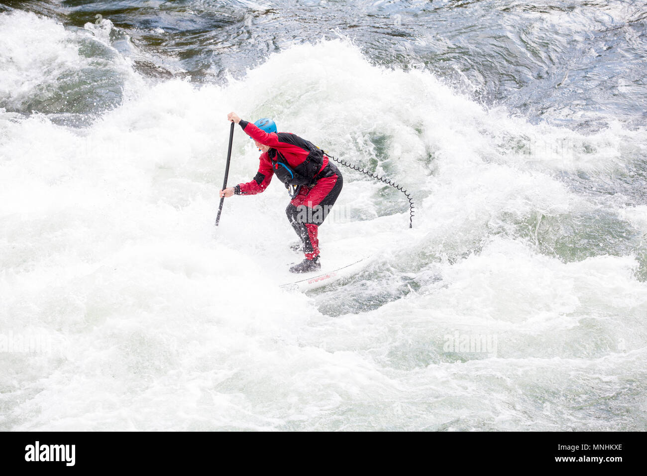 Man navigating whitewater rapids while stand-up paddleboarding on Snake River, Jackson, Wyoming, USA Stock Photo