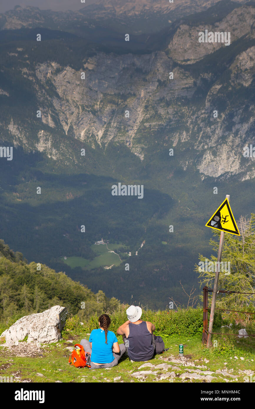 Man and woman having picnic and enjoying view over Julian Alps from mount Vogel, Slovenia Stock Photo