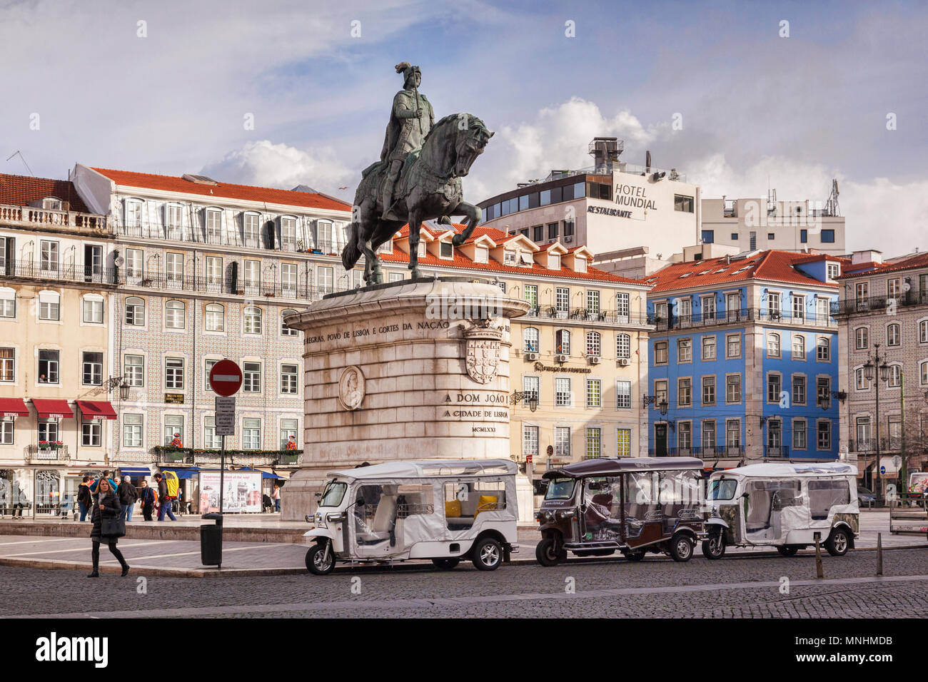 27 February 2018: Lisbon, Portugal - Tuk tuks lined up beneath the equestrian statue of Dom Joao or John 1 in Figueira Plaza on a sunny morning in lat Stock Photo