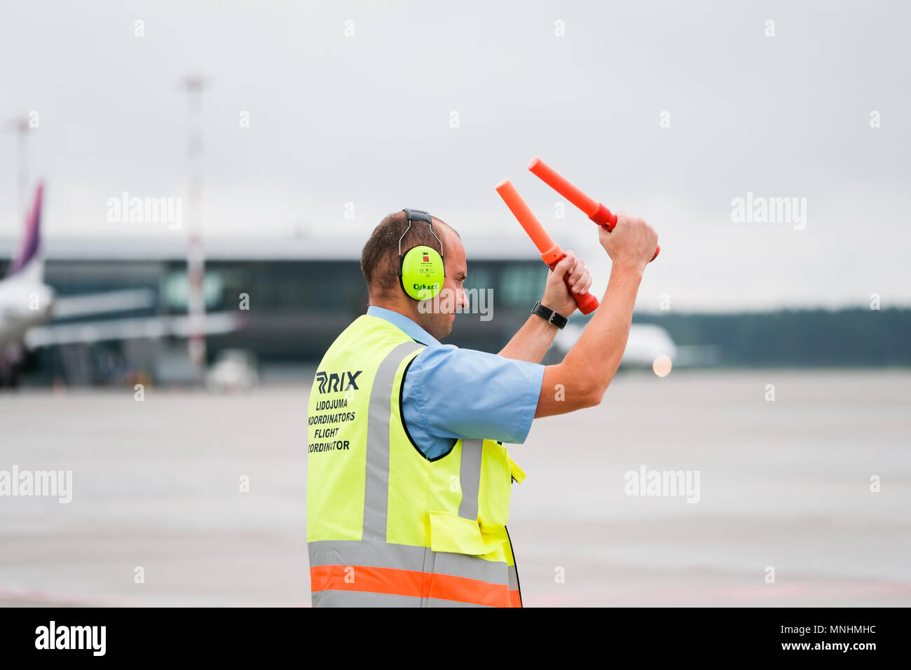 RIGA, JULY 2017 flight coordinator is guiding an airplane to its