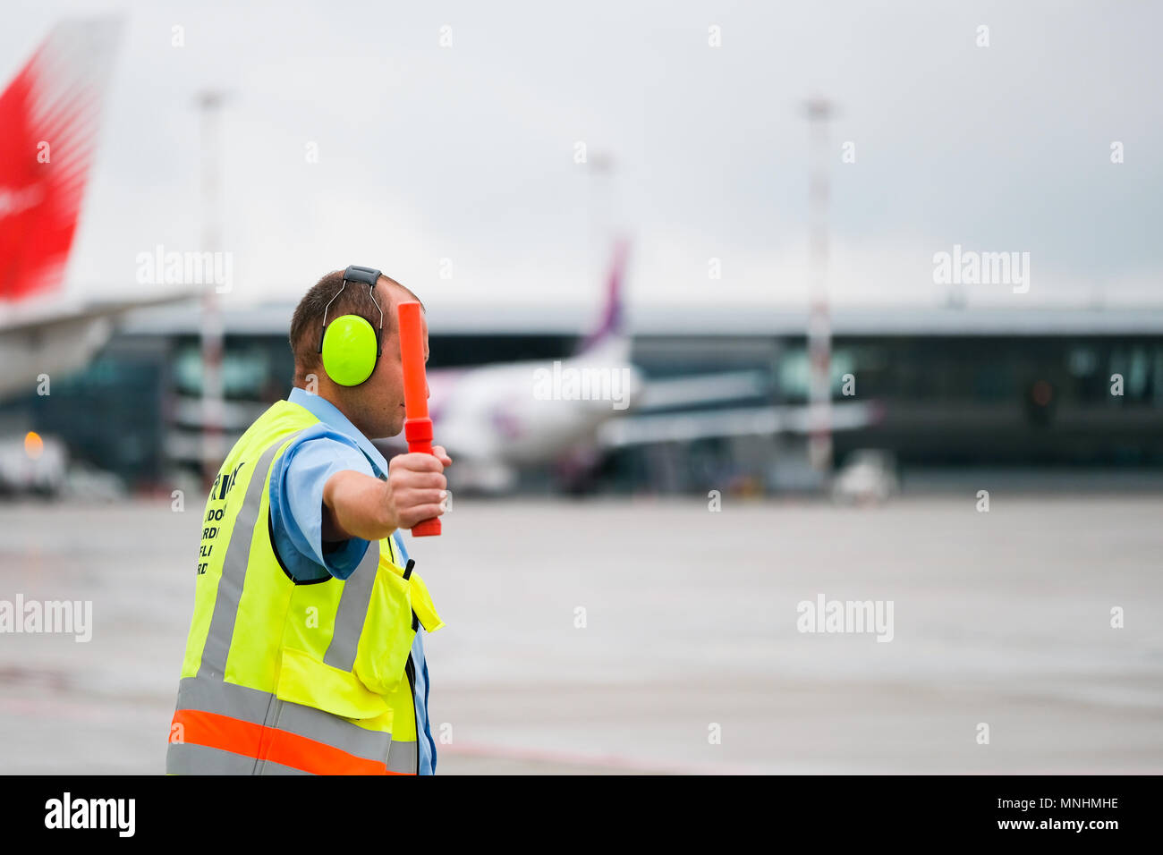 Flight coordinator is guiding an airplane to its parking spot at the airport  Stock Photo - Alamy