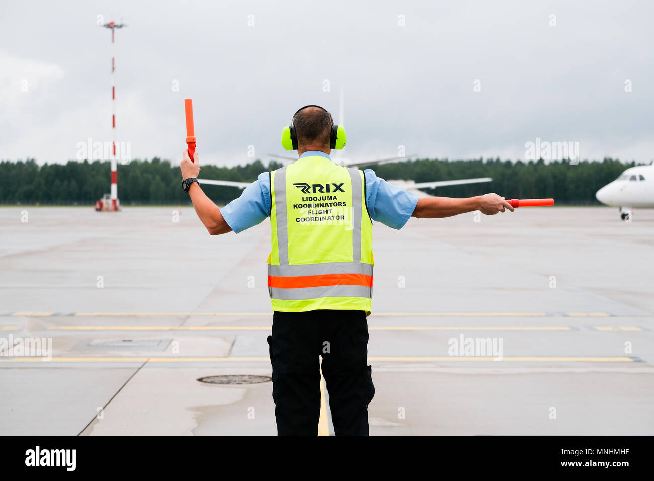 RIGA, JULY 2017 flight coordinator is guiding an airplane to its