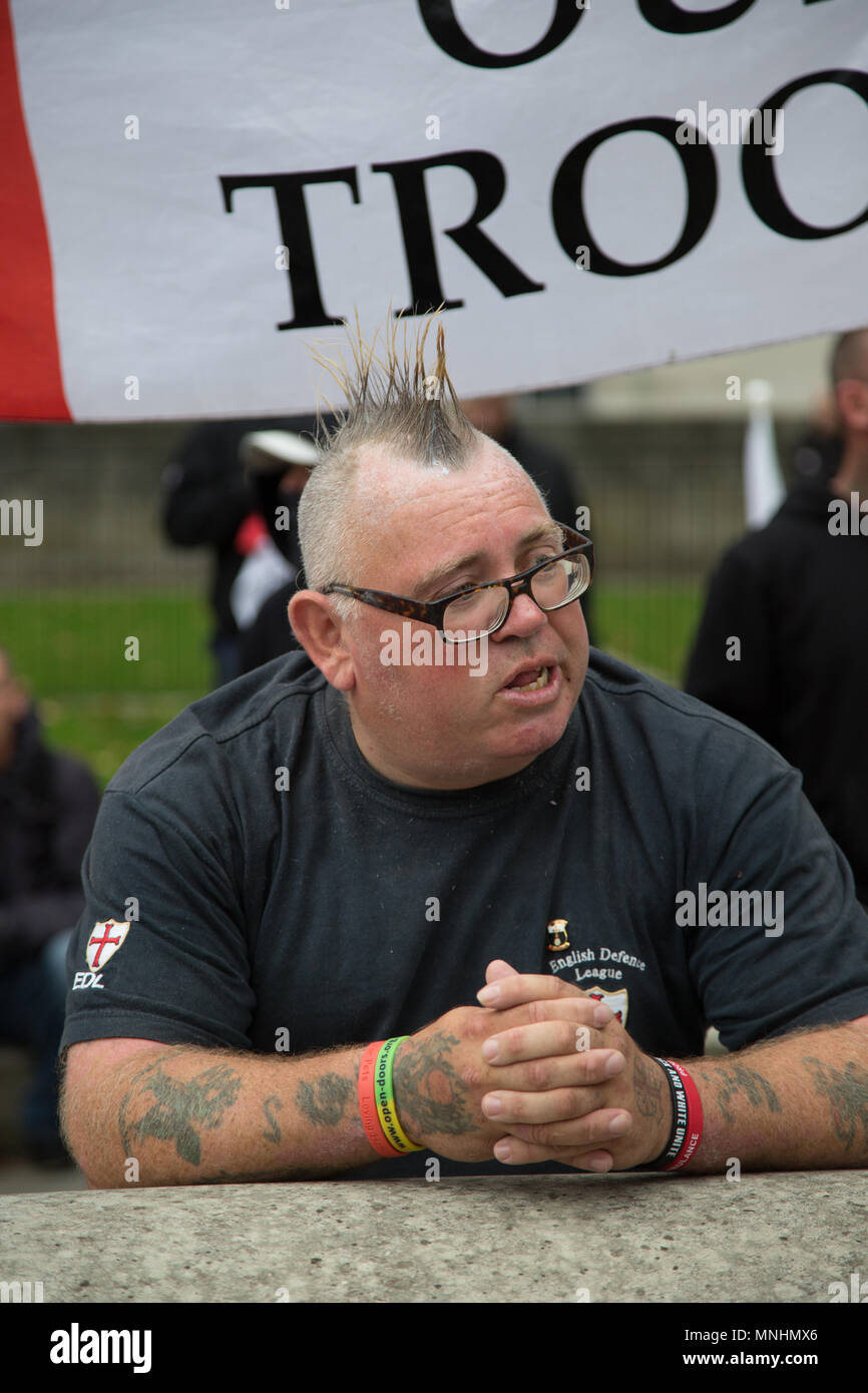 A member of the EDL stands in front of a support our troops banner Stock Photo