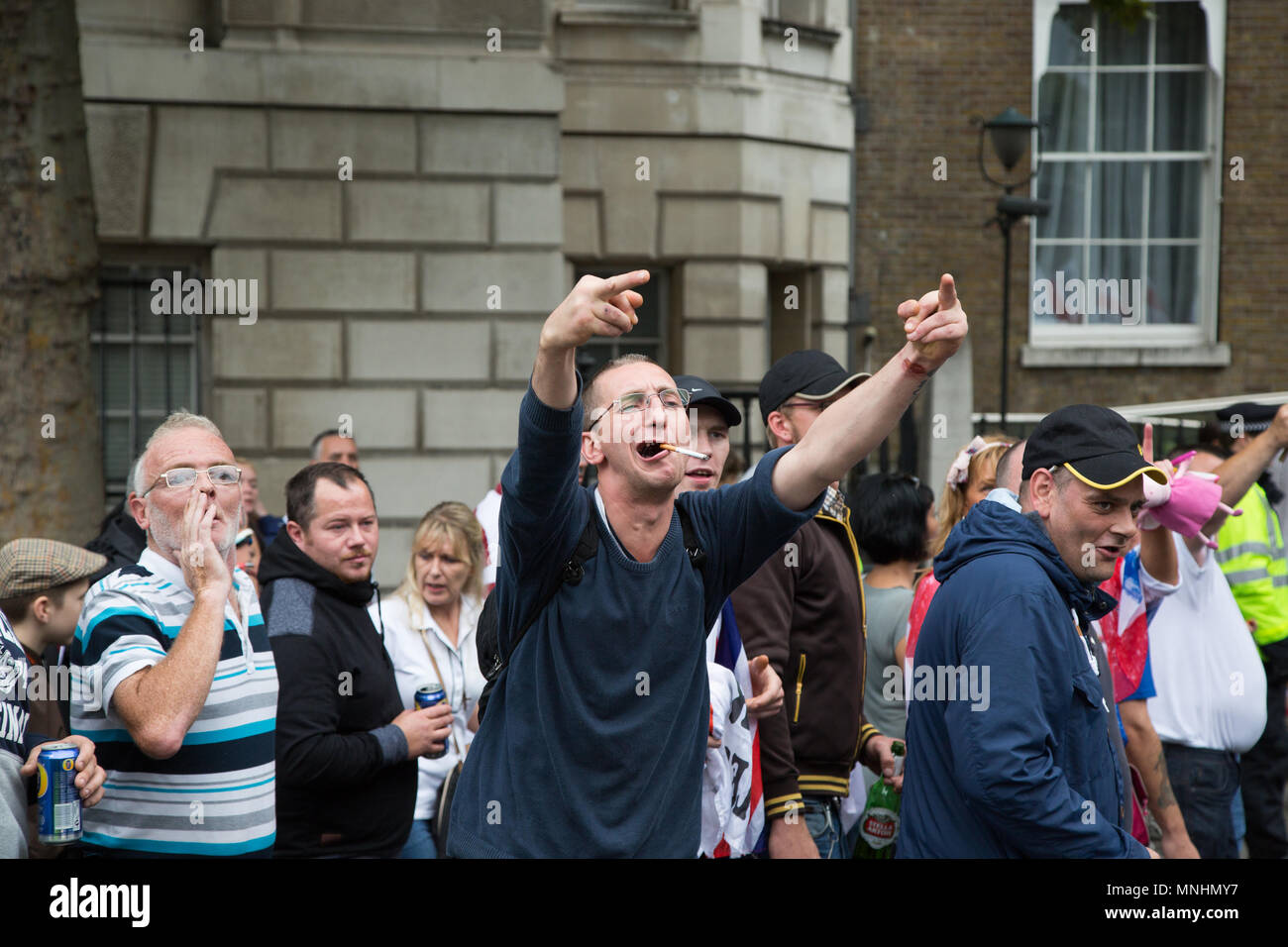 A man sticks his fingers up at opposing crowds during an EDL demonstration Stock Photo
