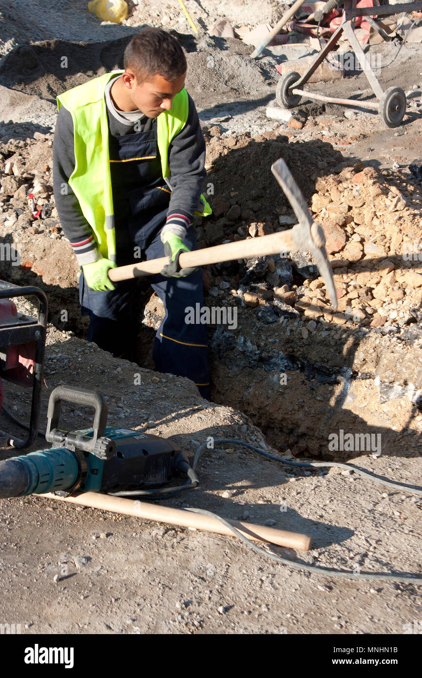 Man digging with pickaxe pavement hires stock photography and images