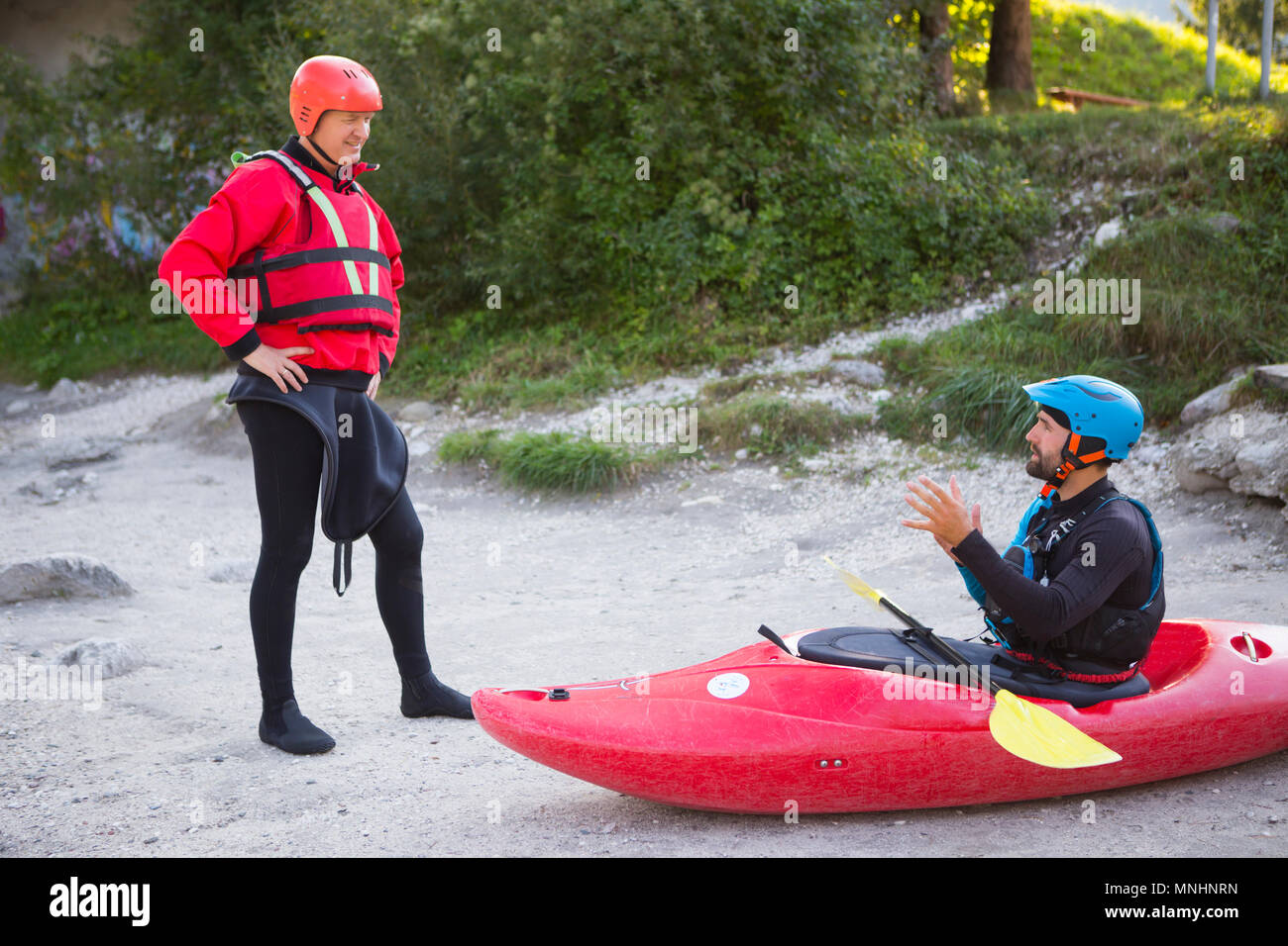 A kayak wild water guide is explaining the safety procedures to a tourist who is going to have a wet adventure on the Soca river near Bovec in Slovene Littoral, Slovenia Stock Photo