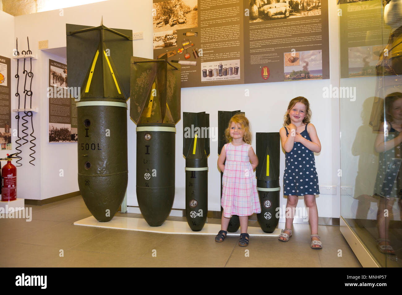 Display of bombs of various sizes used by axis countries Germany & Italy against Malta during World War II. Accompanied by young children child kid kids at the Malta at War Museum in Malta Stock Photo