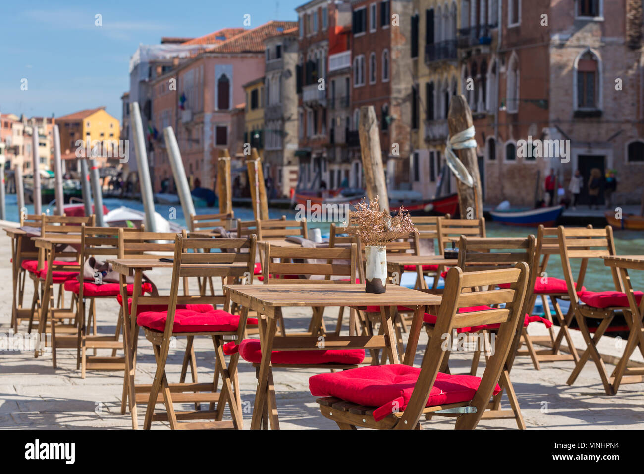 Street view of a cafe terrace with empty tables and chair in Venice, Italy. Stock Photo