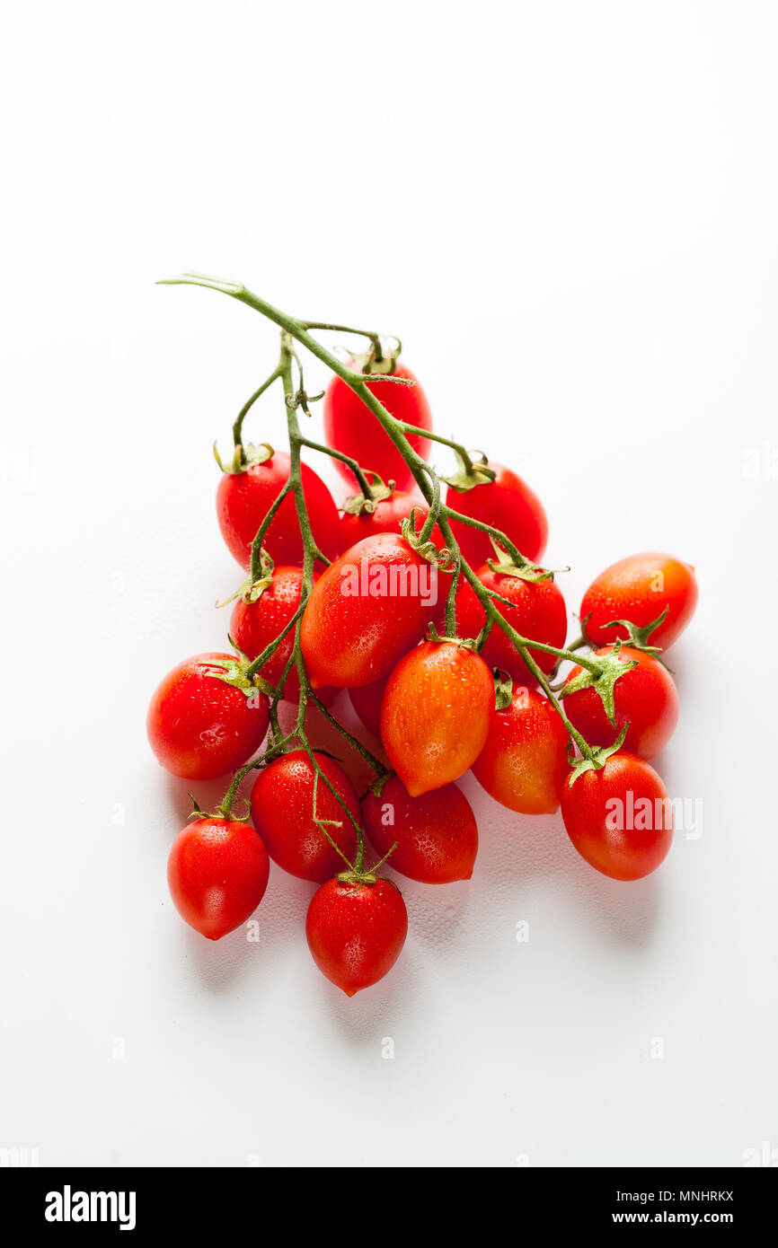 a bunch of small wet cherry tomatoes isolated on white Stock Photo - Alamy