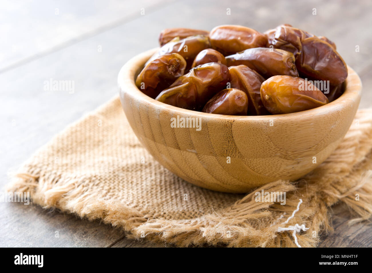 dates food in wooden bowl on wooden table Stock Photo