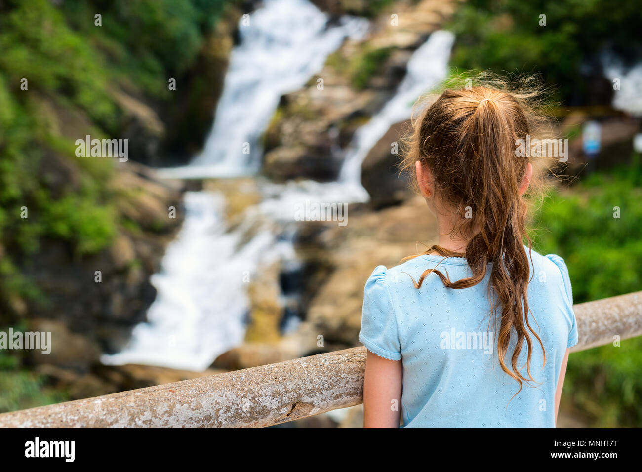 Young girl enjoying views over Ravana Ella waterfalls in Sri Lanka from a viewpoint Stock Photo