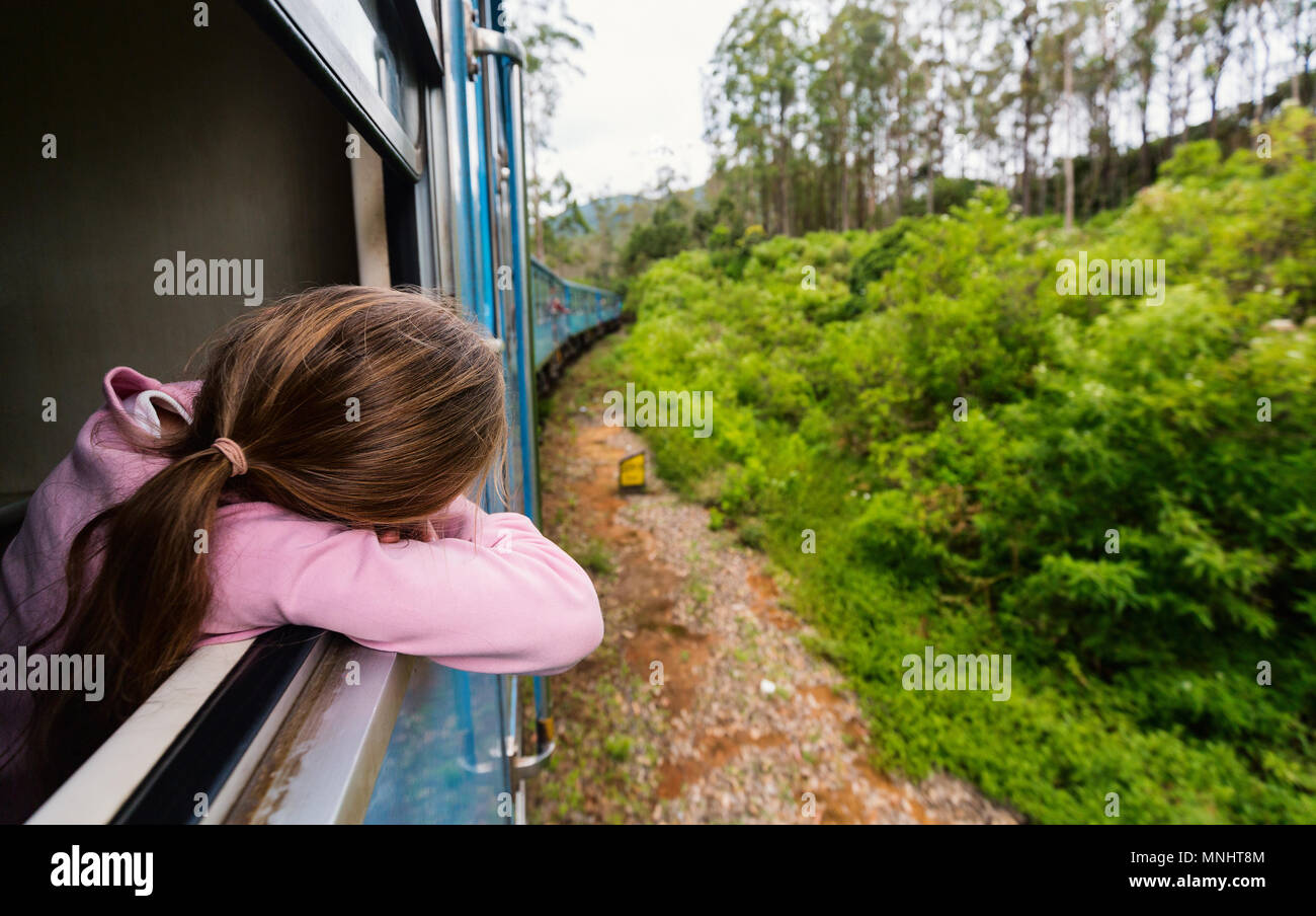 Little girl enjoying train ride from Ella  to Kandy among tea plantations in the highlands of Sri Lanka Stock Photo
