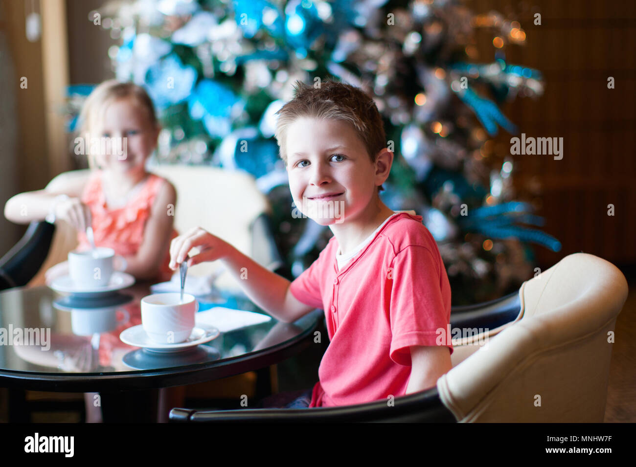 Two children drink tea from white cups Stock Photo