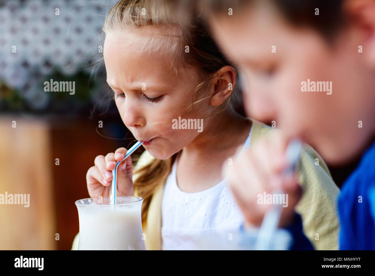 Kids brother and sister drinking milkshakes in outdoor cafe Stock Photo