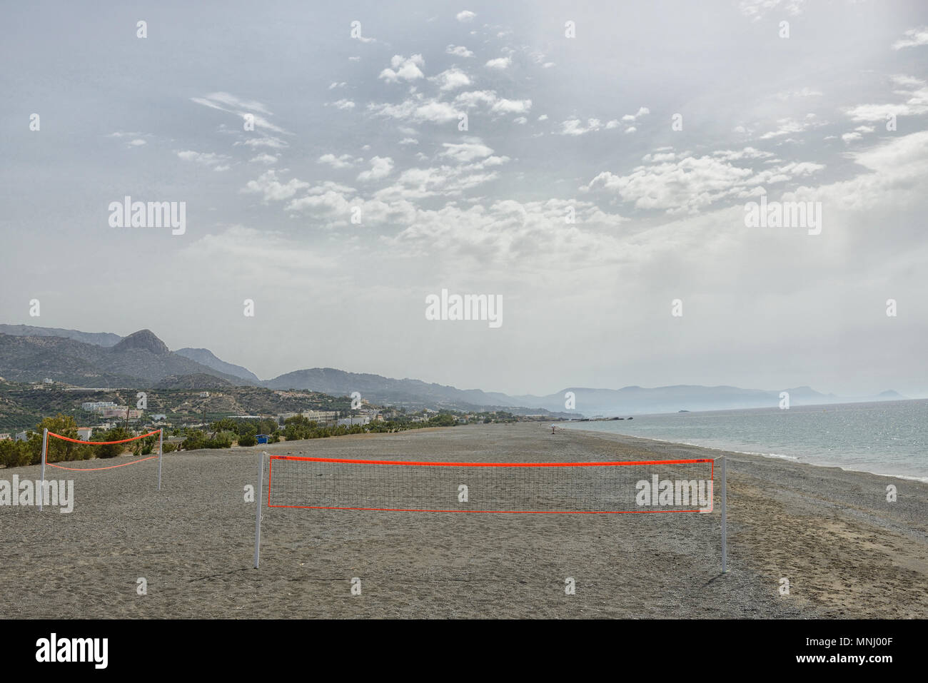 The view of the beach and mountains in the background with a net for beach volleyball Stock Photo