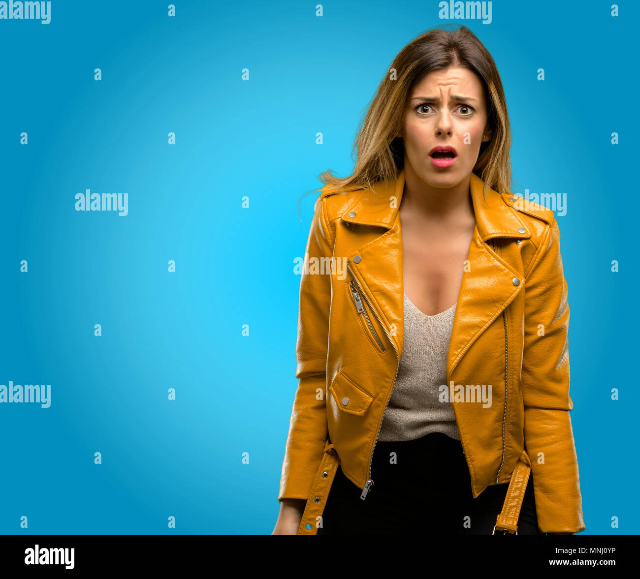 Beautiful young woman scared in shock, expressing panic and fear, blue ...