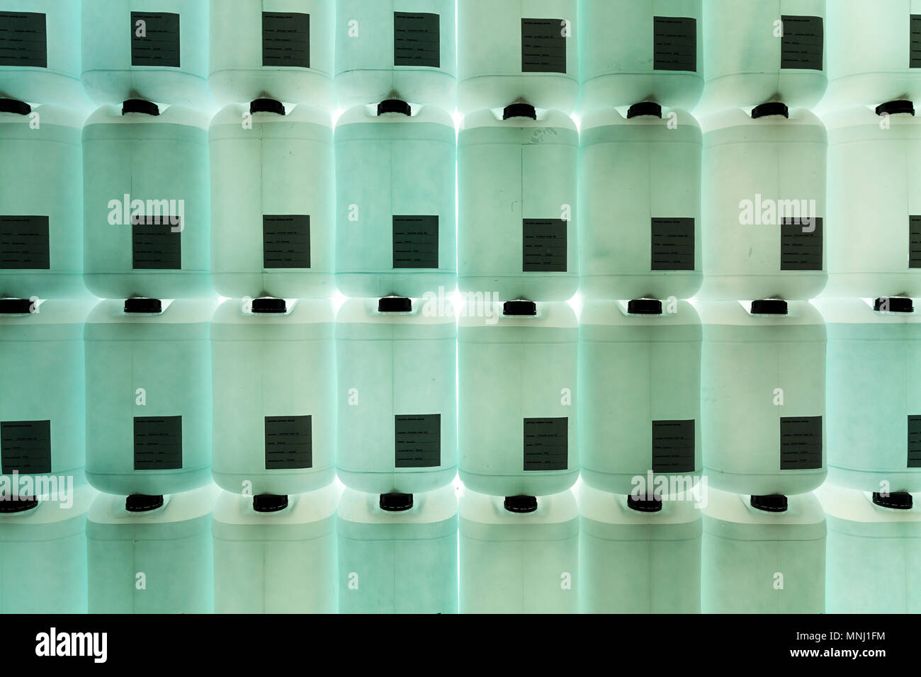 A wall of plastic translucent water canisters, chemicals, lab Stock Photo