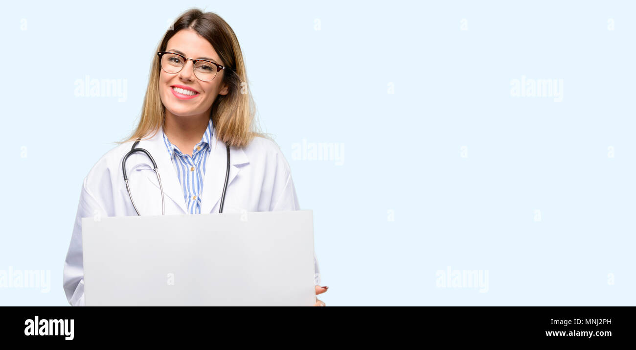 Young doctor woman, medical professional holding blank advertising banner, good poster for ad, offer or announcement, big paper billboard Stock Photo