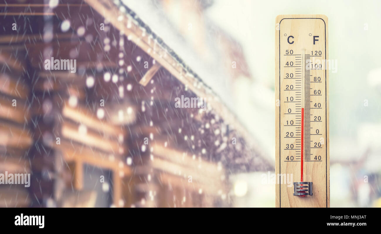 Thermometer displaying 5 degrees celsius or 40 fahrenheit, in the background house and rainy weather. Stock Photo