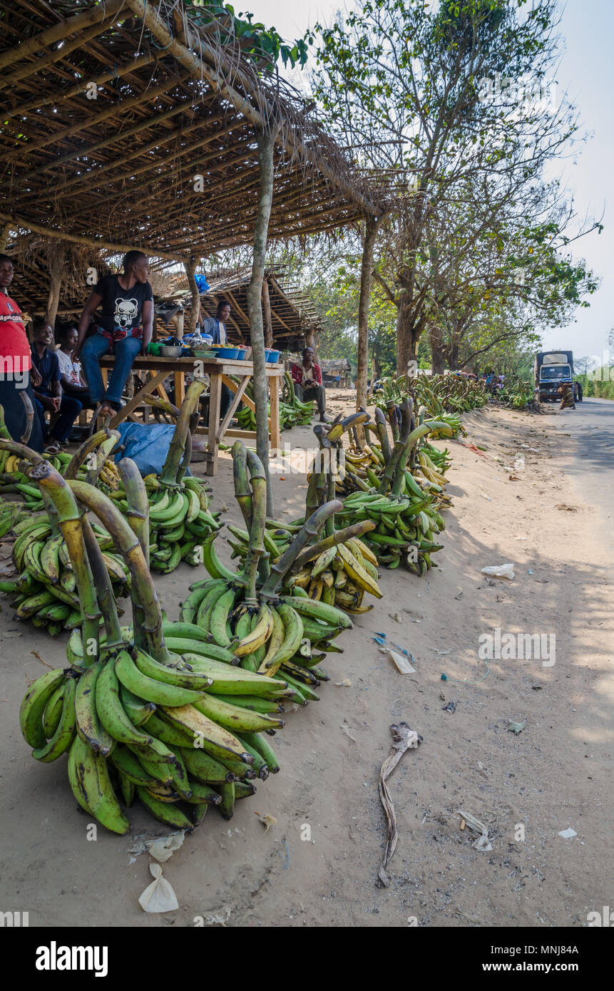 Green and yellow plantains and other vegetables for sale at road market Stock Photo