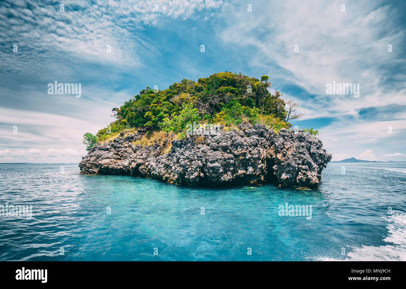 Wonderful scene the limestone rock covered with the vegetation in the ocean next to the exotic Phi Phi Islands, the Kingdom of Thailand. Beauty of wil Stock Photo