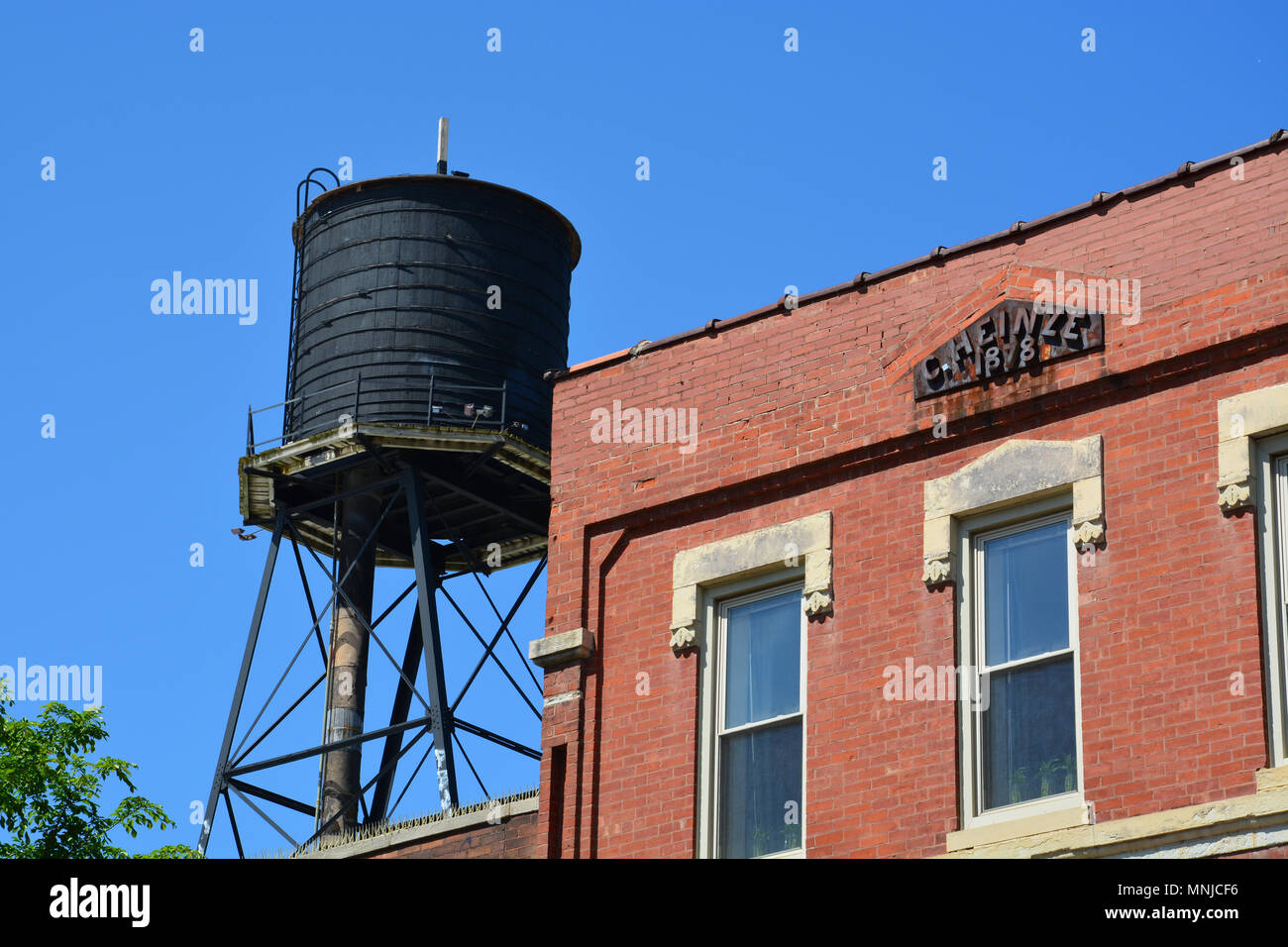 An old water tower still stands next to an apartment building built in 1878 on Milwaukee Avenue in the trendy Wicker Park neighborhood of Chicago. Stock Photo